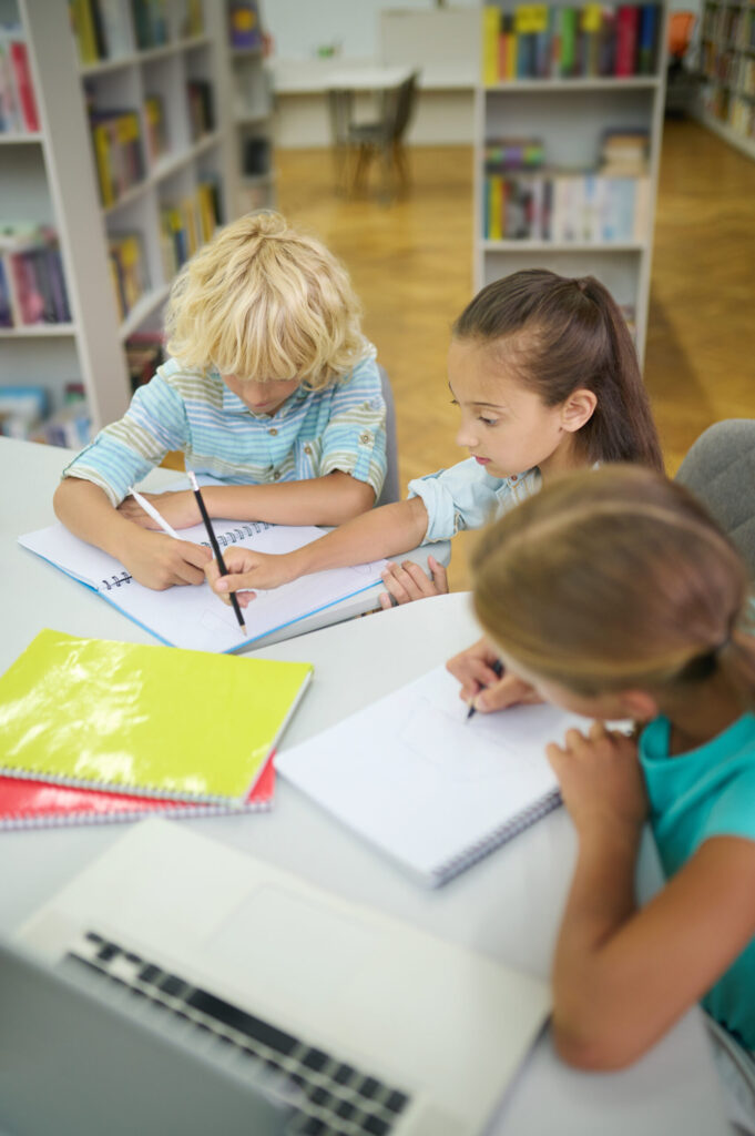 girls boy doing lessons library scaled.jpg