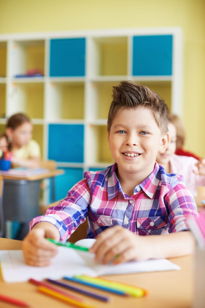 kid smiling with green pencil scaled.jpg